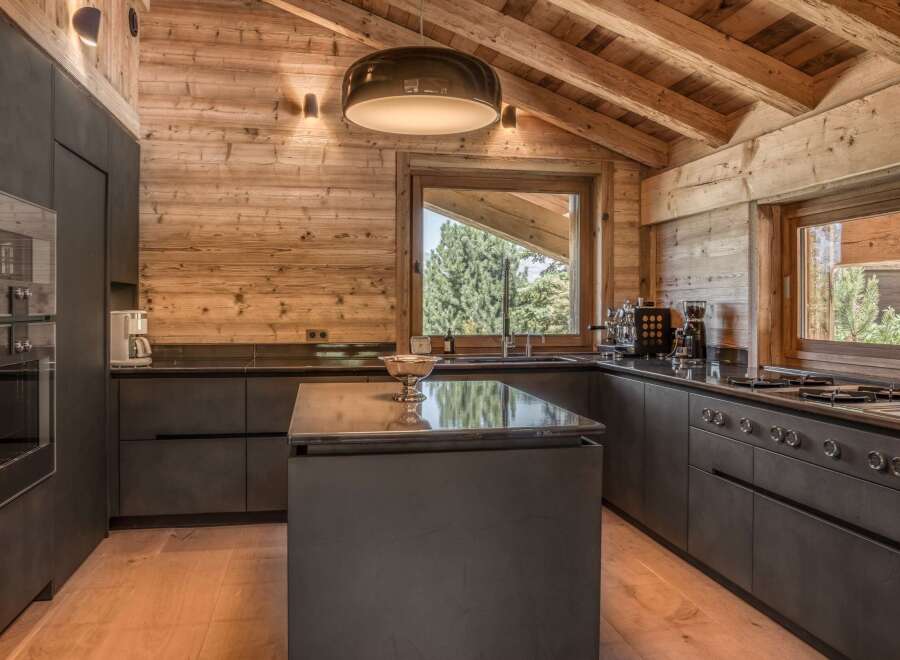 This stunning kitchen boasts a rustic charm with its wooden walls and ceiling, creating a warm and inviting atmosphere.