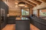 This stunning kitchen boasts a rustic charm with its wooden walls and ceiling, creating a warm and inviting atmosphere.