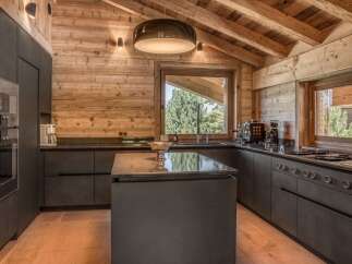 This stunning kitchen boasts a rustic charm with its wooden walls and ceiling, creating a warm and inviting atmosphere.