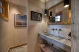 This rustic bathroom features a unique stone sink and wooden accents, creating a warm and inviting atmosphere.