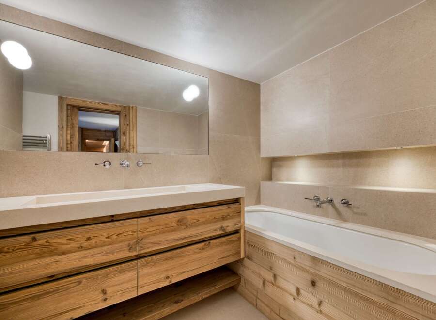This luxurious bathroom features a stunning wooden vanity with ample storage and a sleek, modern design.