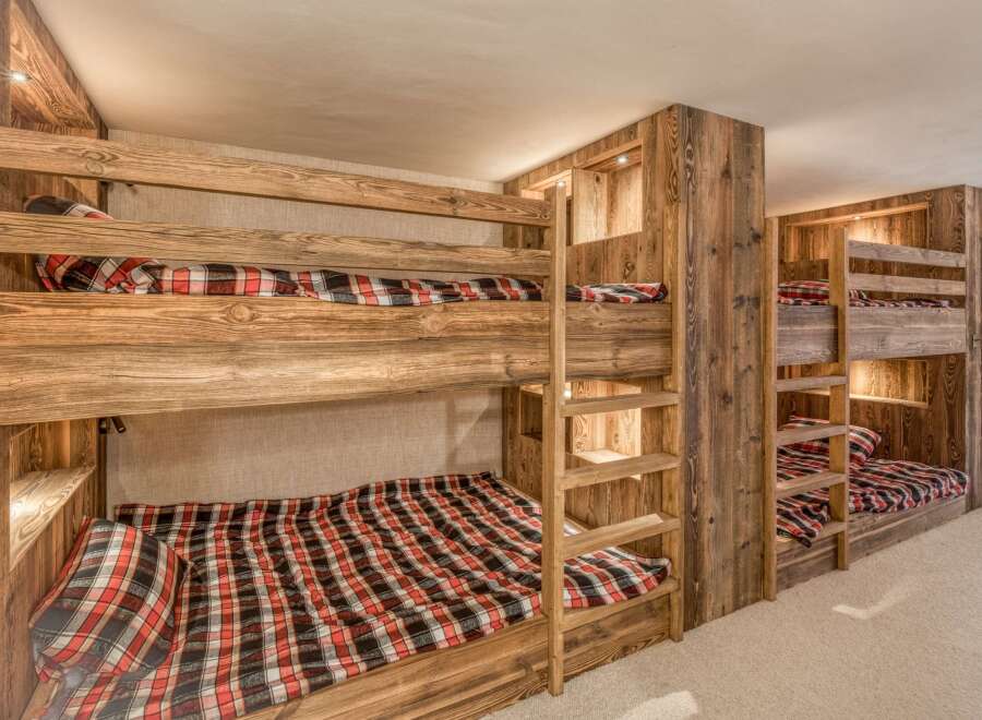 This cozy bedroom features custom-built bunk beds with rustic wooden frames, perfect for accommodating multiple guests.