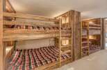This cozy bedroom features custom-built bunk beds with rustic wooden frames, perfect for accommodating multiple guests.