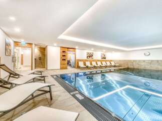 Indulge in a relaxing swim in our pristine indoor pool, surrounded by comfortable lounge chairs perfect for unwinding after a refreshing dip.