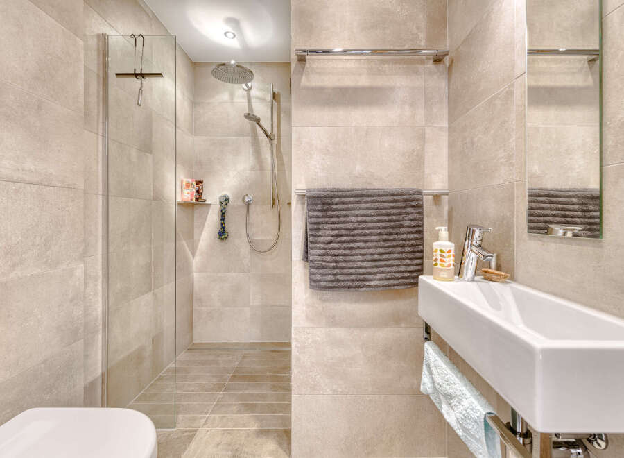 Step into a modern bathroom oasis! This stunning space features a sleek walk-in shower with a glass enclosure, complemented by elegant tile work.