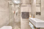Step into a modern bathroom oasis! This stunning space features a sleek walk-in shower with a glass enclosure, complemented by elegant tile work.