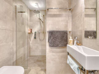 Step into a modern bathroom oasis! This stunning space features a sleek walk-in shower with a glass enclosure, complemented by elegant tile work.