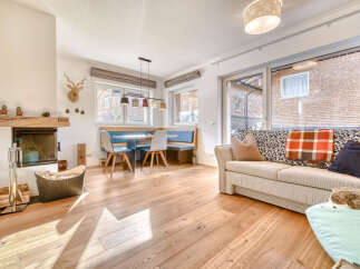 Discover the charm of this inviting living space, featuring a cozy fireplace and warm wooden floors.