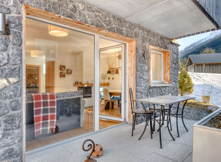 Experience the charm of this stunning property, featuring a beautiful stone exterior and a cozy outdoor patio.