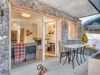 Experience the charm of this stunning property, featuring a beautiful stone exterior and a cozy outdoor patio.