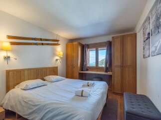 Cozy bedroom with wooden accents and mountain views.