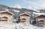 Discover luxurious chalets nestled in a breathtaking snowy mountain setting.