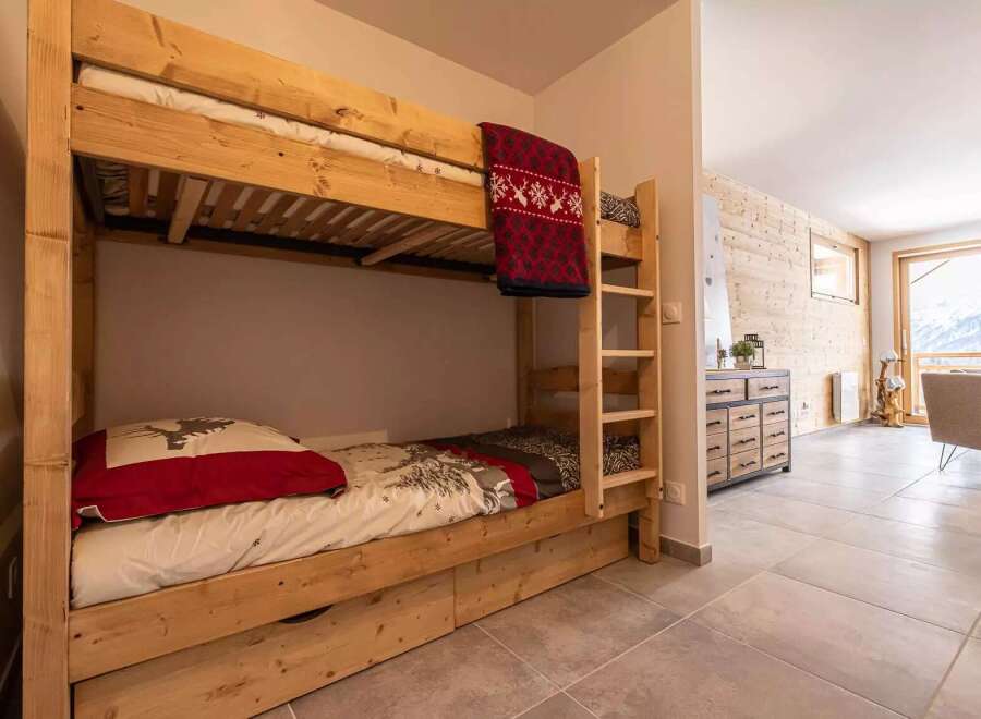 Cozy wooden bunk beds with built-in drawers provide comfortable sleeping arrangements in this charming chalet.