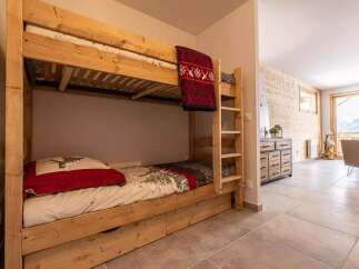 Cozy wooden bunk beds with built-in drawers provide comfortable sleeping arrangements in this charming chalet.