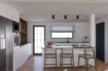 Modern kitchen with herringbone floors and sleek appliances.