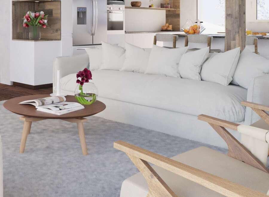 Stunning living room with a cozy white sofa and wooden armchairs, perfect for relaxing after a day on the slopes.