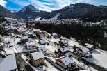 Discover a charming mountain village nestled in a snowy landscape, perfect for a serene getaway.