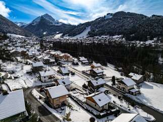Discover a charming mountain village nestled in a snowy landscape, perfect for a serene getaway.