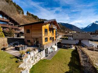 Experience luxury mountain living in this stunning wooden chalet, featuring expansive balconies and a spacious outdoor deck perfect for entertaining.