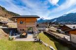 Experience luxury mountain living in this stunning wooden chalet, featuring a spacious outdoor deck perfect for al fresco dining with breathtaking alpine views.