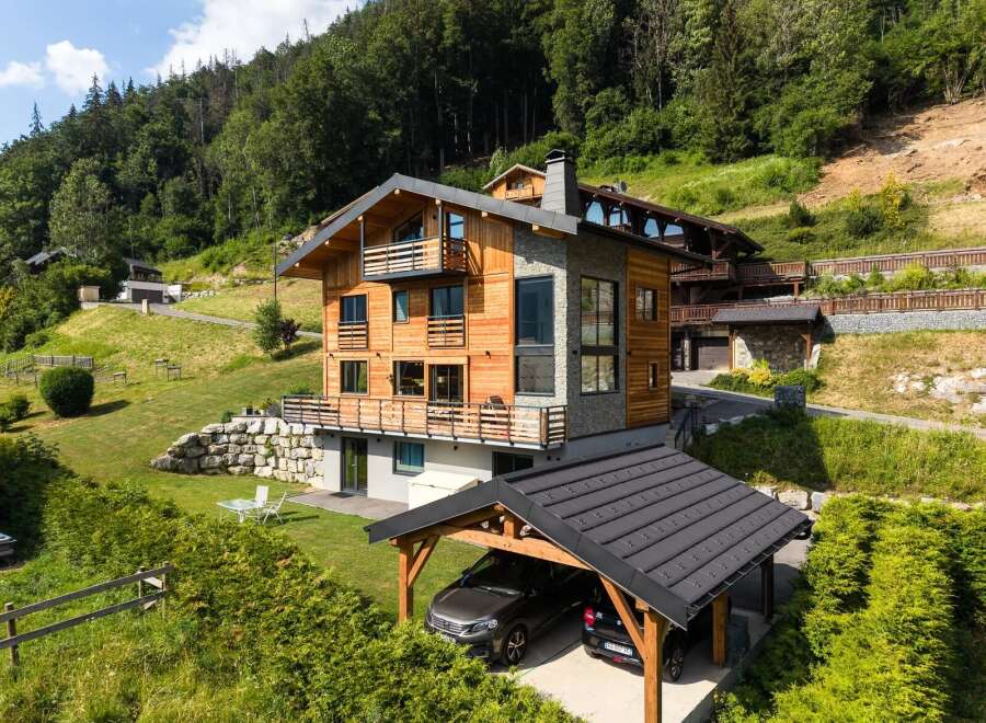 Experience luxury mountain living in this stunning chalet, featuring a modern design with warm wood accents and stone detailing.