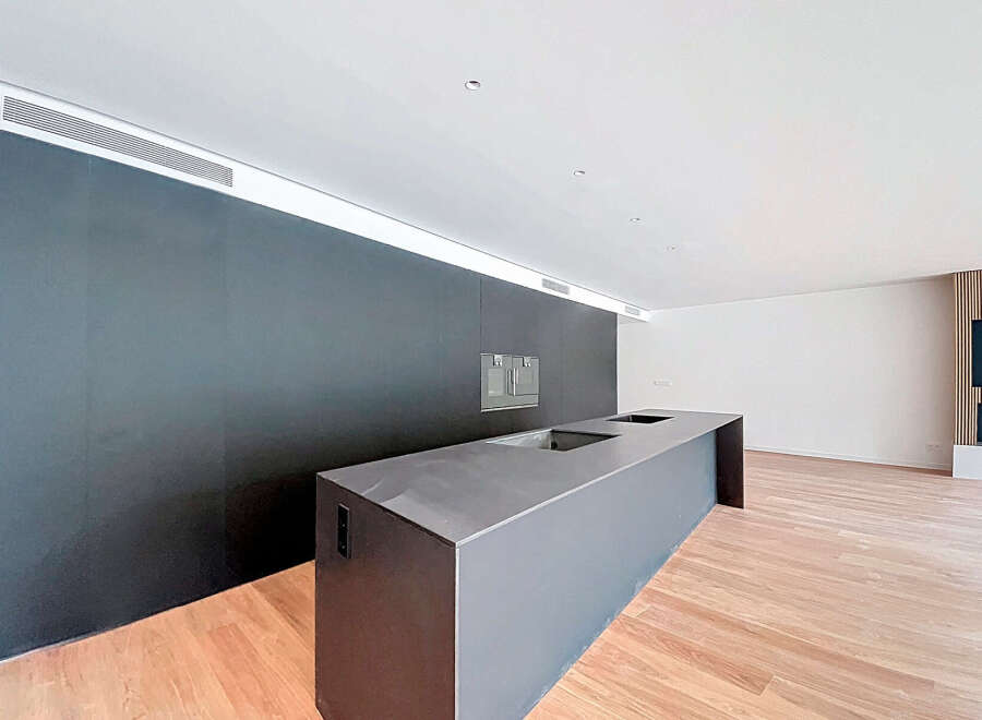Modern kitchen island with sleek dark gray countertop and integrated sink.