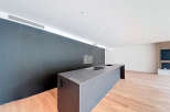Modern kitchen island with sleek dark gray countertop and integrated sink.