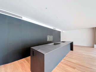 Modern kitchen island with sleek dark gray countertop and integrated sink.