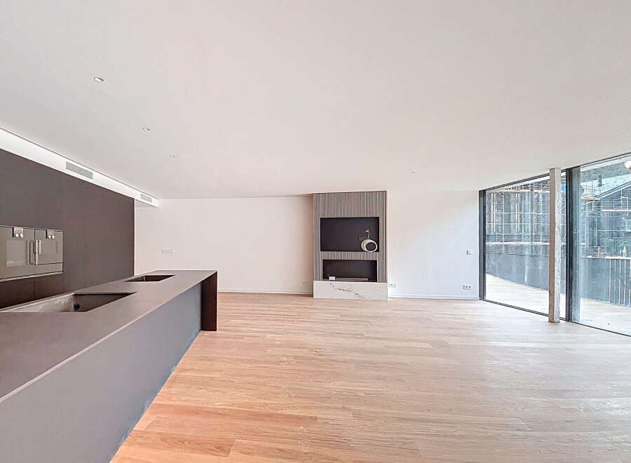 Stunning open-plan living space with sleek modern kitchen and expansive windows offering breathtaking views.