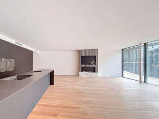 Stunning open-plan living space with sleek modern kitchen and expansive windows offering breathtaking views.