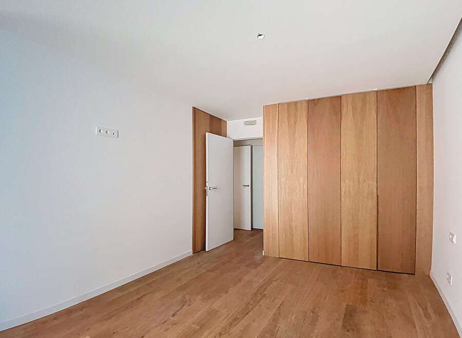 This stunning property boasts a spacious bedroom with sleek, modern hardwood floors and built-in wooden closet.