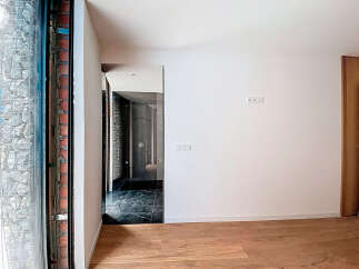 Modern minimalist interior with sleek glass door and hardwood floors.