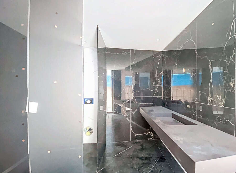 Luxury bathroom with marble walls and a floating concrete vanity.