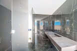 Luxury bathroom with marble walls and a floating concrete vanity.