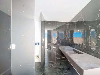 Luxury bathroom with marble walls and a floating concrete vanity.
