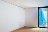 This stunning property boasts a spacious, bright room with sleek white walls and elegant light oak hardwood flooring.