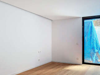 This stunning property boasts a spacious, bright room with sleek white walls and elegant light oak hardwood flooring.