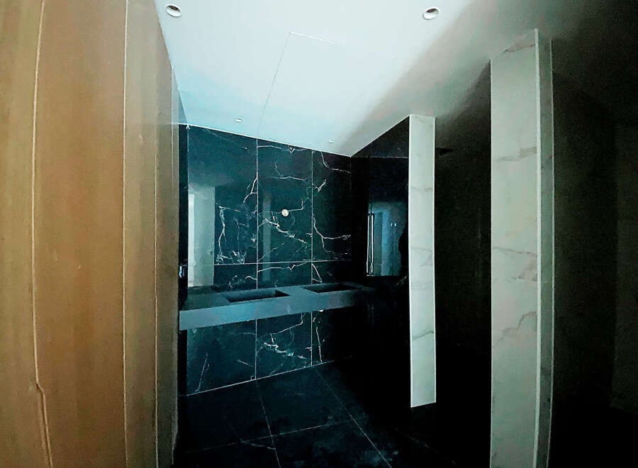 Luxury bathroom with dark marble tiles and modern double vanity.