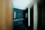Luxury bathroom with dark marble tiles and modern double vanity.