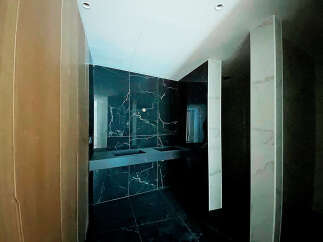 Luxury bathroom with dark marble tiles and modern double vanity.