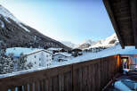 Luxury chalet with breathtaking mountain views and a private balcony featuring comfortable outdoor seating.
