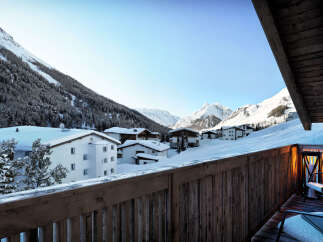 Luxury chalet with breathtaking mountain views and a private balcony featuring comfortable outdoor seating.