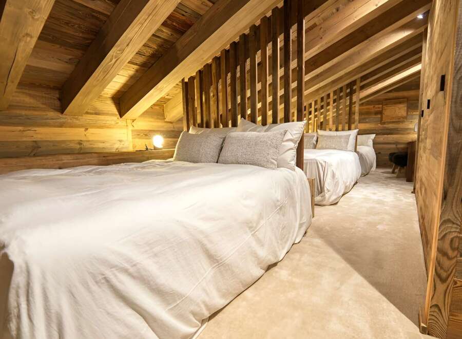 Cozy chalet bedroom with rustic wood beams and plush bedding.