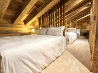 Cozy chalet bedroom with rustic wood beams and plush bedding.