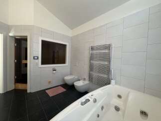 This luxurious bathroom features a modern design with sleek, light-colored tiles and a spacious layout.