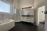 This modern bathroom features a sleek design with a luxurious bathtub and a separate shower.