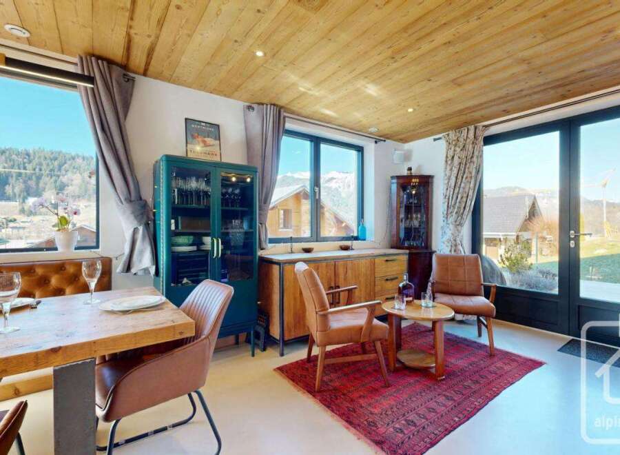 Experience the charm of this stunning property, boasting a beautifully designed dining area with a rustic wooden table and comfortable seating.