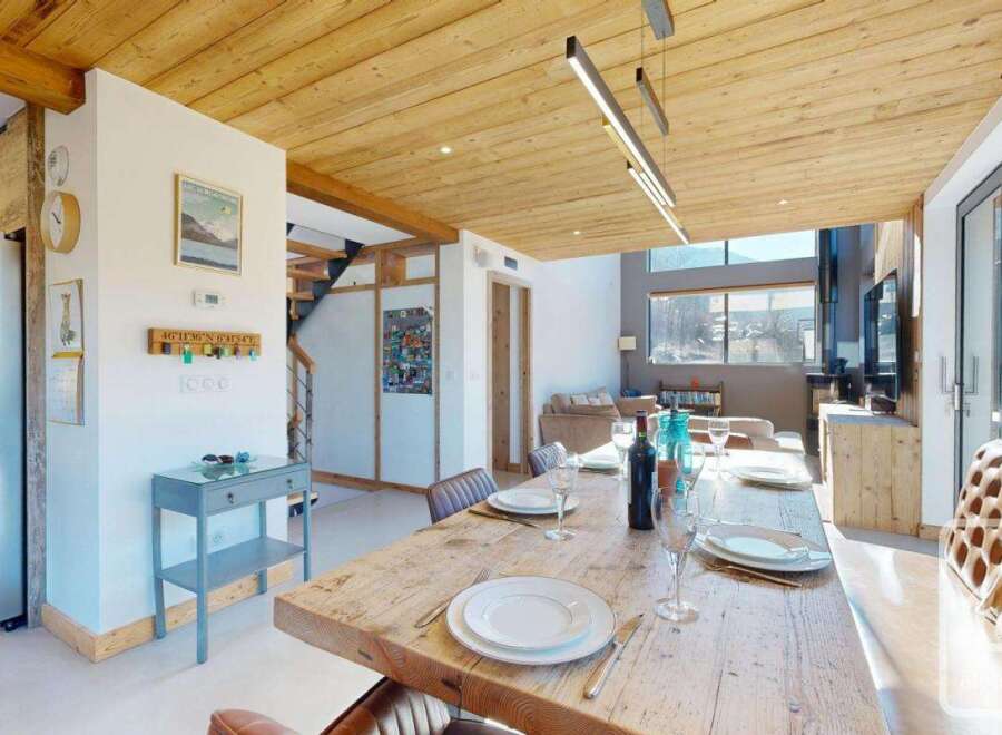 Experience the charm of this stunning property, featuring a rustic wooden dining table perfect for gatherings.