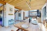 Experience the charm of this stunning property, featuring a rustic wooden dining table perfect for gatherings.