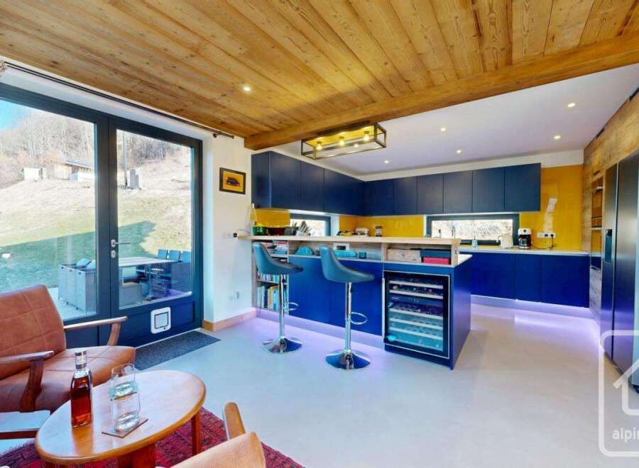 This stunning property boasts a modern kitchen with sleek blue cabinetry and a vibrant yellow backsplash, perfect for culinary enthusiasts.